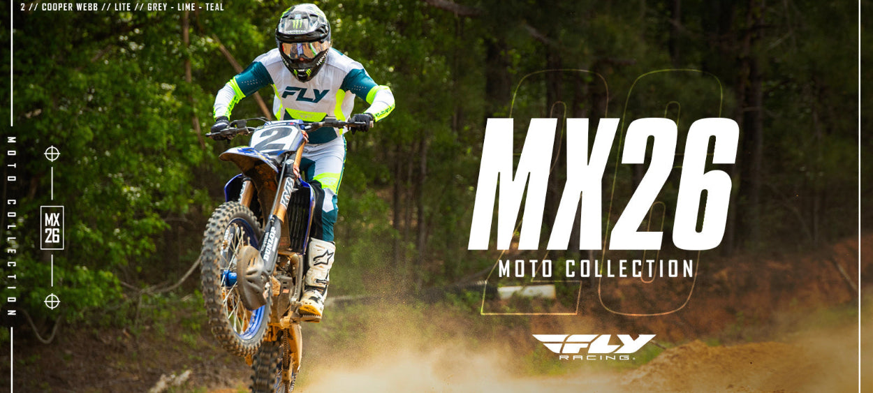 Person riding a dirt bike with 'MX26 Moto Collection' text and 'FLY' branding in a forest setting.